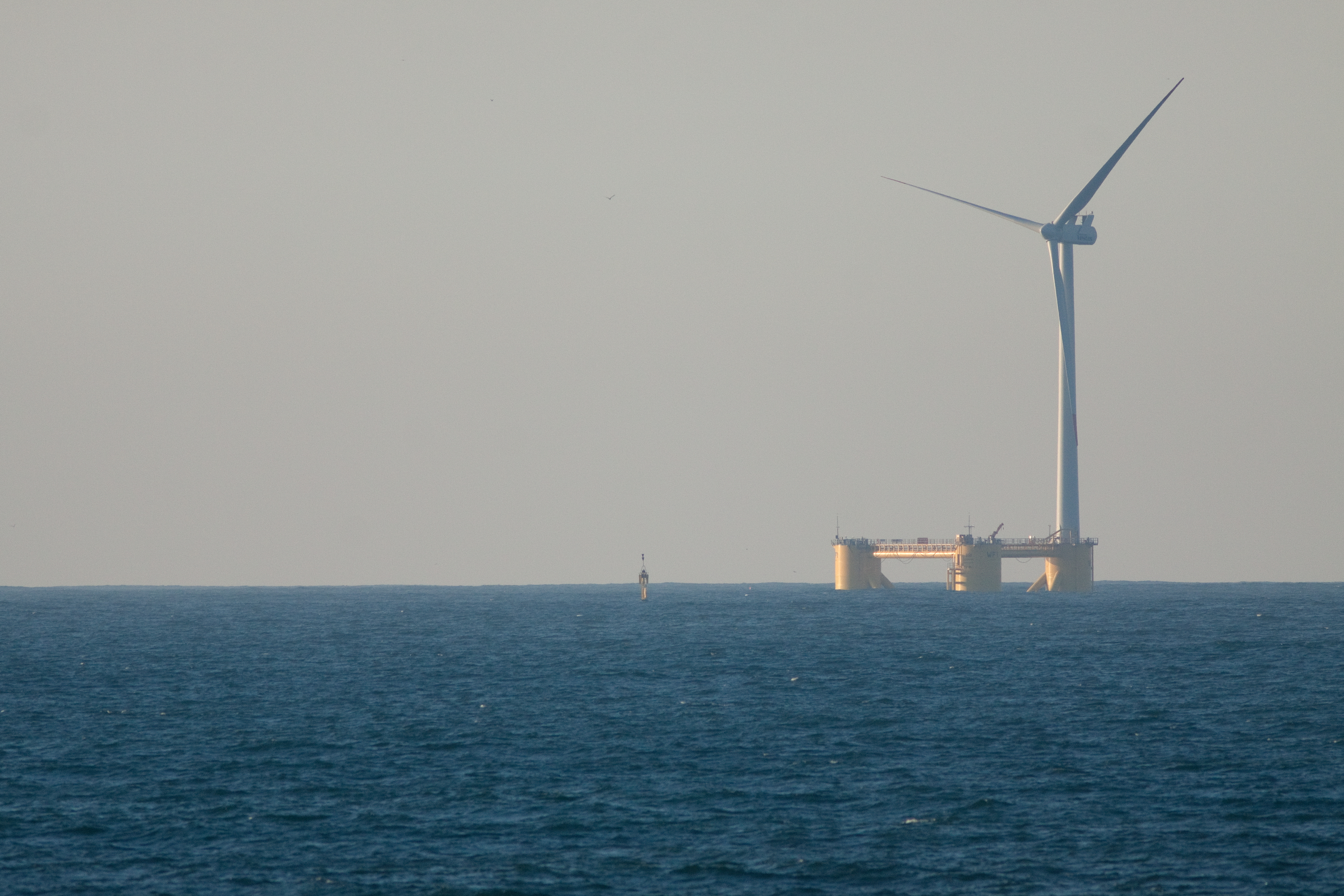 A platform and ship being used to aid while constructing an offshore windturbine